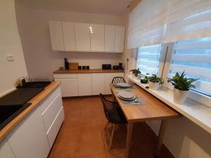 een keuken met een houten tafel en een aanrechtblad bij Kinga in Toruń +2 foto's