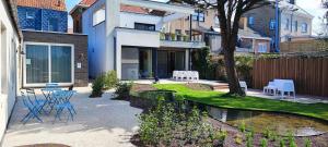 a house with a table and chairs in a yard at B&B Charles Cabour in De Panne