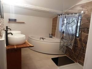 y baño con lavabo, bañera y ducha. en La Cachette, en Aigues-Vives