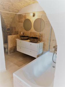 uma casa de banho com 2 lavatórios e uma banheira em La Cachette em Aigues-Vives