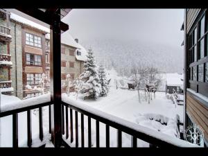 Una vista de un patio cubierto de nieve desde un balcón. en BACIVER de Alma de Nieve, en Naut Aran (Alto Arán)