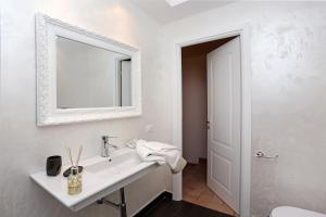 a white bathroom with a sink and a mirror at Madonna de' Monti Suites in Rome