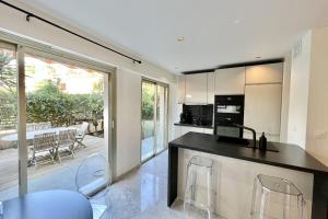 a kitchen with a counter and chairs and a patio at Superb luxury Flat garden pool tennis in Le Cannet