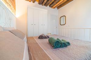 a bedroom with a bed with towels on the floor at Casetta Stretta Bersaglio in Chioggia