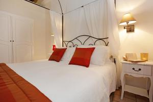 a bedroom with a white bed with red pillows at Madonna de' Monti Suites in Rome