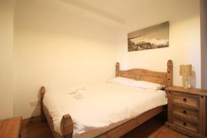 a bedroom with a wooden bed and a nightstand and a bed sidx sidx sidx at Seaside Views in Galway