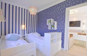 a bedroom with a blue and white striped wall at Apartamenty Bryza - Ulanska - Parking in Świnoujście