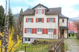 uma casa grande com persianas vermelhas e brancas em Schlafen zur Brauerei St. Johann em Nesslau