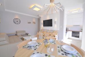 a dining room and living room with a table and chairs at Apartamenty Bryza - Ulanska - Parking in Świnoujście