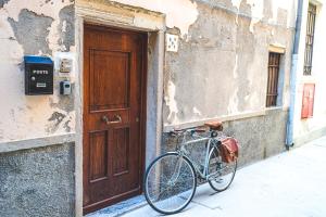 a bike parked next to a building with a door at Casetta Stretta Bersaglio in Chioggia