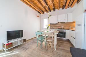 a kitchen with white cabinets and a table and chairs at Casetta Stretta Bersaglio in Chioggia