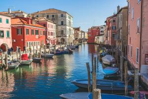 a group of boats docked in a canal with buildings at Casetta Stretta Bersaglio in Chioggia