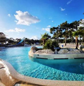 - une piscine d'eau bleue dans un parc dans l'établissement Mobil home Premium Camping 5*, à Vendays-Montalivet