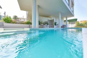 a swimming pool in a house with blue water at ApartmentsGarda - Le Terrazze Del Garda Residence in Lazise