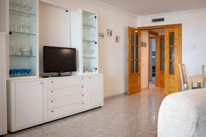 Televízia a/alebo spoločenská miestnosť v ubytovaní AT080 Pins, comunidad con piscina en 1ra línea de la playa
