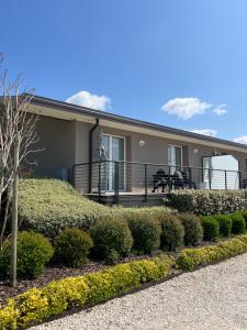 a house with a balcony and some bushes at Agricamping Al grappolo diVino in Lazise