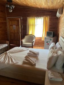 1 dormitorio con 1 cama grande y toallas. en Oran Ağaç Bungalovs, en Kemer