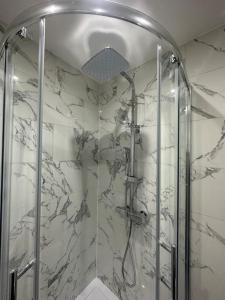 La salle de bains est pourvue d'une douche avec une porte en verre. dans l'établissement 2 Bedroom house,BrownhillRd SE6, à Londres