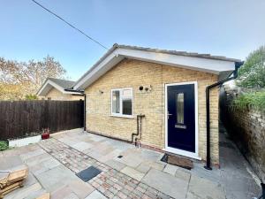 a brick house with a black door and a patio at 2 Bedroom house,BrownhillRd SE6 in London