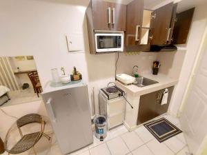 a small kitchen with a refrigerator and a microwave at Cityland Prime Residences by KF in Tagaytay