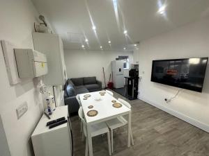 a living room with a white table and a couch at 2 Bedroom house,BrownhillRd SE6 in London