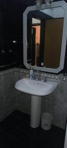 ein Badezimmer mit Waschbecken und Spiegel in der Unterkunft Casa con quincho y pileta in Cordoba