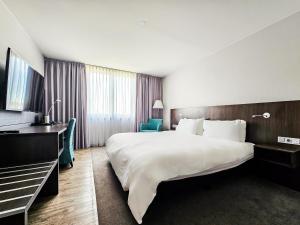 Habitación de hotel con cama grande y TV en Valemi Stay - Selfservice, en Düsseldorf