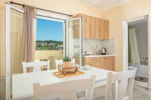 a kitchen and dining room with a white table and chairs at Premier Tsilivi in Tsilivi