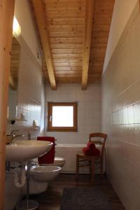 La salle de bains est pourvue de 2 toilettes, d'un lavabo et d'une baignoire. dans l'établissement Agritur Fiore, à Fondo