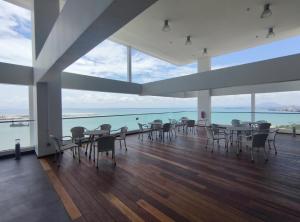 comedor con mesas y sillas y vistas al océano en Seaview Duplex Sunrise Gurney 2BR 一级棒海景の楼中楼, en George Town