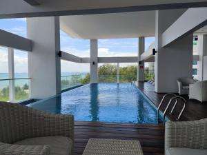 a large swimming pool in a building with windows at Seaview Duplex Sunrise Gurney 2BR 一级棒海景の楼中楼 in George Town