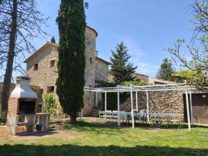 a garden with a table and chairs in front of a building at La Rectoria de Dosquers 24p in Maia de Montcal