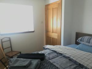 1 Schlafzimmer mit 2 Betten und einer Holztür in der Unterkunft Lovely 1-Bed Cottage in Hopeman in Elgin