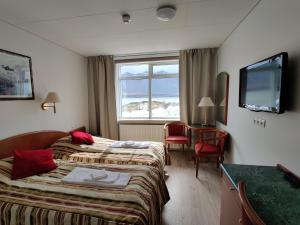 um quarto de hotel com duas camas e uma televisão em Hótel Borgarnes em Borgarnes