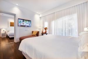 a white bedroom with a large bed and a window at Magna Pars l'Hotel à Parfum in Milan