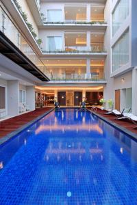 a large swimming pool in a building at Ohana Hotel Kuta in Kuta
