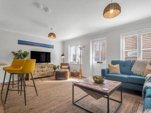a living room with a blue couch and yellow chairs at Pass the Keys Stunning 2 Bed House by the Sea in Whitstable