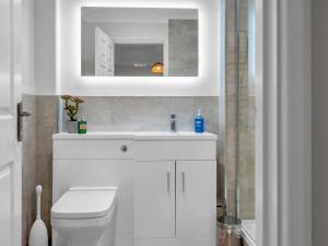a white bathroom with a sink and a mirror at Pass the Keys Stunning 2 Bed House by the Sea in Whitstable +25 photos