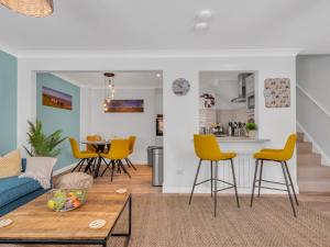 a living room with yellow chairs and a blue couch at Pass the Keys Stunning 2 Bed House by the Sea in Whitstable