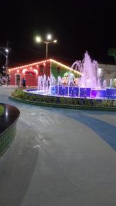 a fountain in the middle of a parking lot at night at Apartamento na Passarela in Porto Seguro