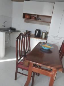 kuchnia z drewnianym stołem z miską w obiekcie Apartamento na Passarela w mieście Porto Seguro
