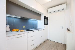 una cocina con armarios blancos y un plato de naranjas en Hedera Estate, Hedera Studio 4, en Dubrovnik