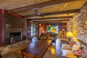 a living room with a stone fireplace and a table at La Manuela, Casa de Campo en las Sierras in Canepa