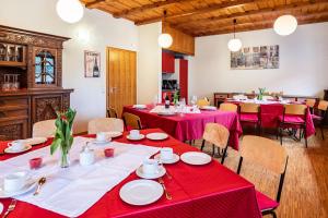 a dining room with tables and chairs with red tablecloths at Altes Pfarrhaus in Vöhrenbach