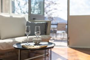 two wine glasses on a table in a living room at Como Lake Vista - by MyHomeInComo in Blevio