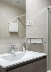 y baño con lavabo blanco y ducha. en BILBAO COSTA-Algorta-Getxo- A ESTRENAR-parking-playa-metro-BILBAO en metro, a 25 mimutos en Getxo