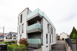 un edificio blanco con un balcón en el lateral. en Primeurs appartement haut standing de 85 m², Luxembourg-Kirchberg en Luxemburgo