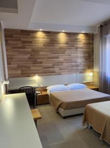 sypialnia z 2 łóżkami i drewnianą ścianą w obiekcie Hotel Europa Parking w mieście Livorno
