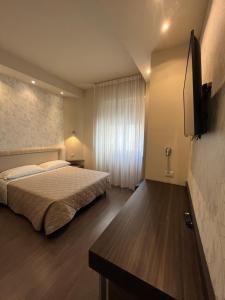 a bedroom with a bed and a flat screen tv at Hotel Europa Parking in Livorno