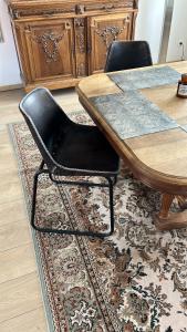 a table with two black chairs sitting on a rug at Haylenes in Tourcoing